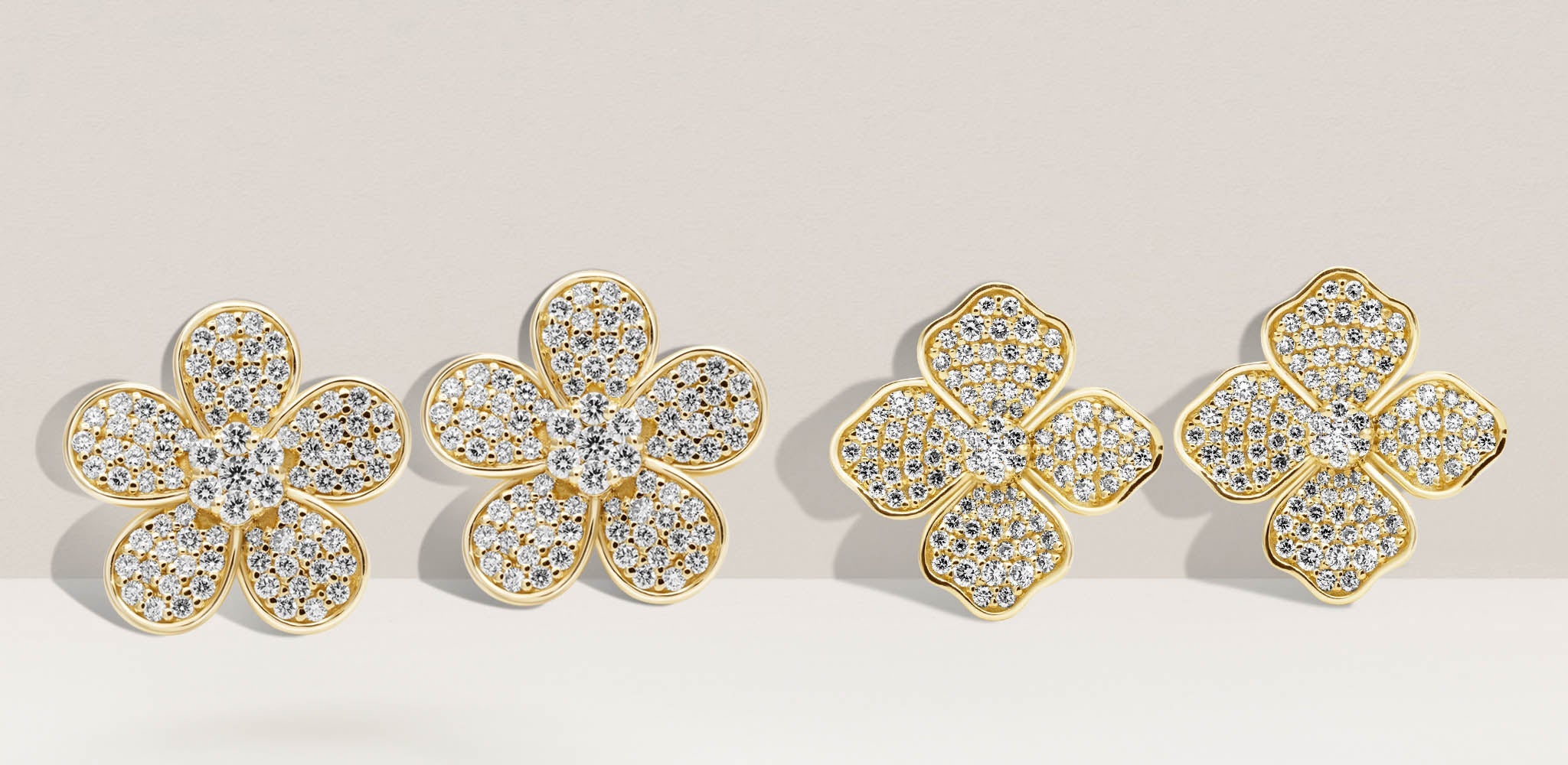 Gold flower-shaped earrings with pavé diamonds and polished gold edges on a soft beige background | Singhvi Jewels Sparkling Diamond Jewelry Collection