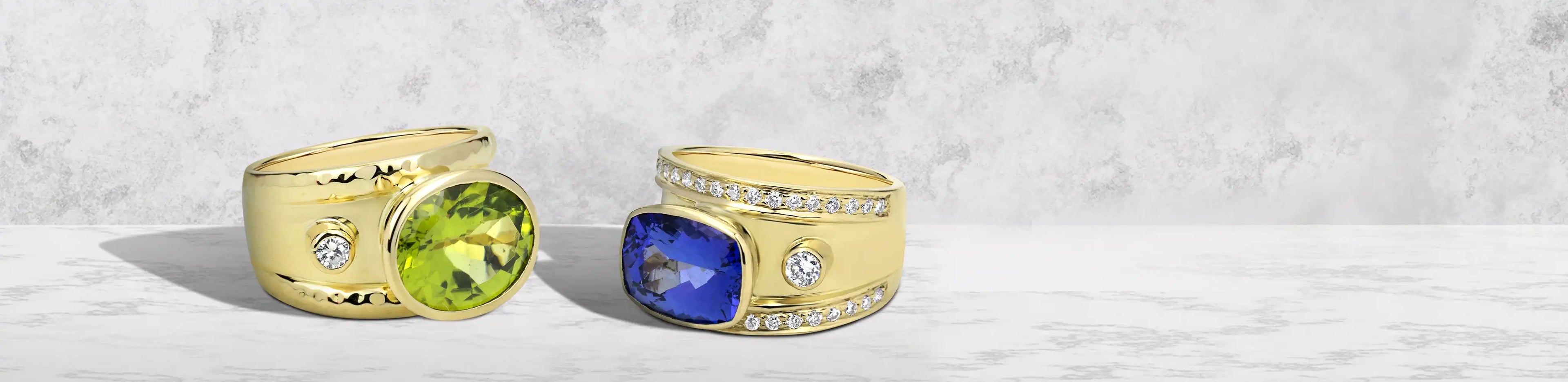 Two gold rings with wide bands, featuring peridot and tanzanite gemstones accented with small diamonds | Singhvi Jewels Rings Collection